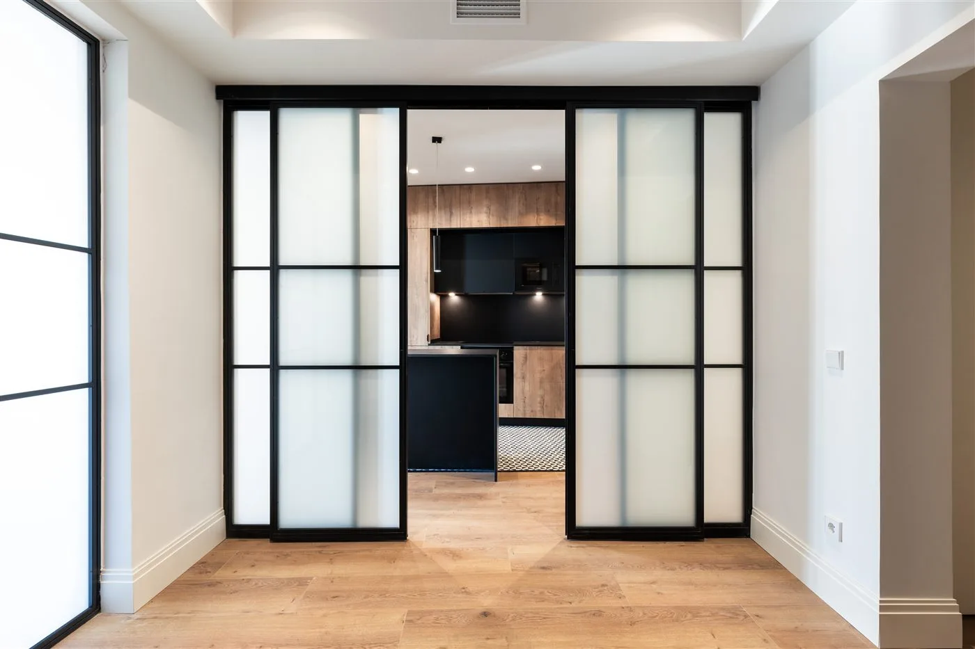 Puerta corredera de cristal esmerilado negro en reforma de piso en Madrid