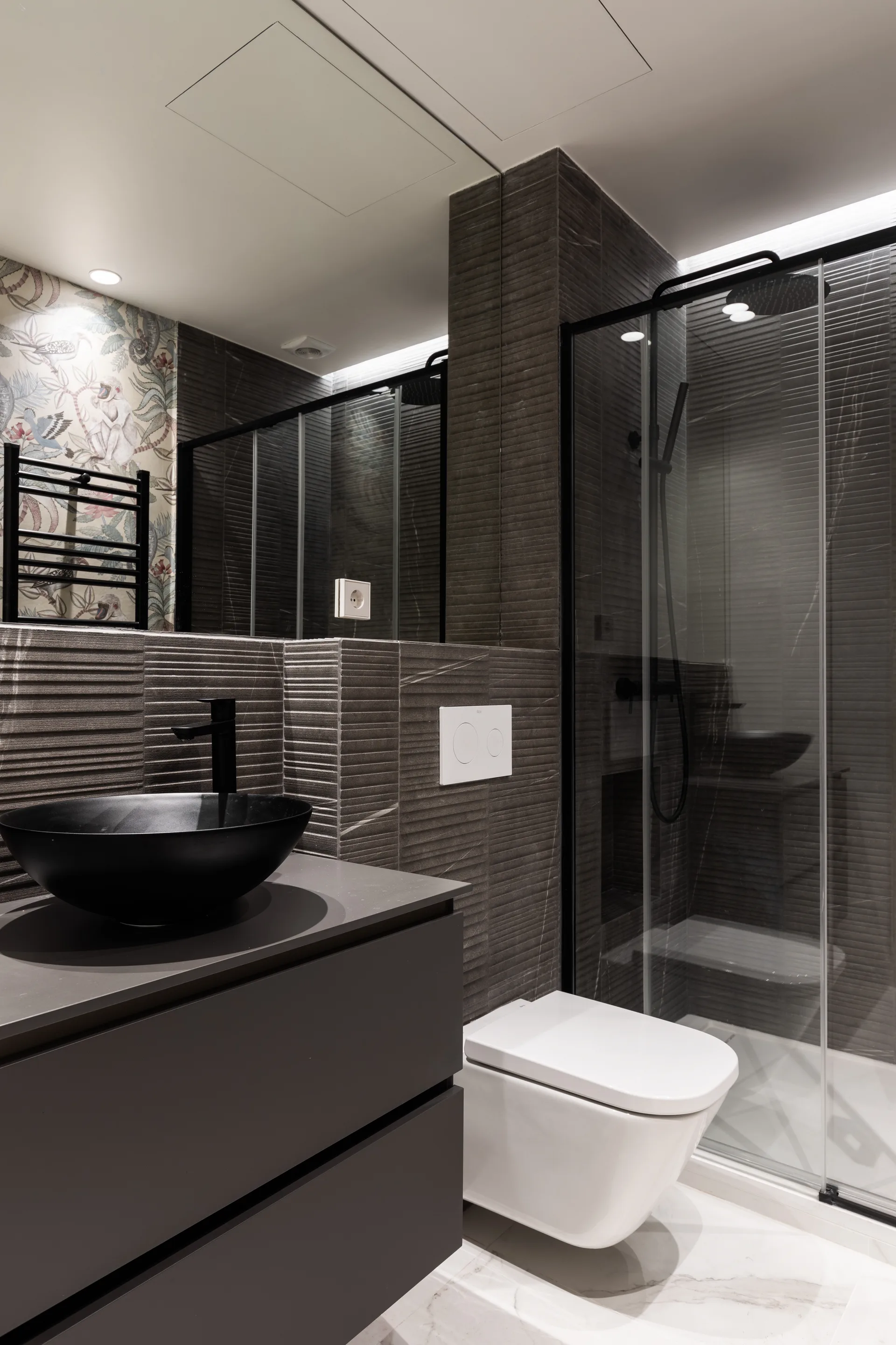 Reforma de baño premium gris oscuro con lavabo bowl negro y ducha en Madrid